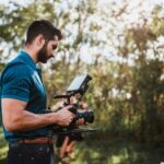 A man standing next to a woman holding a camera