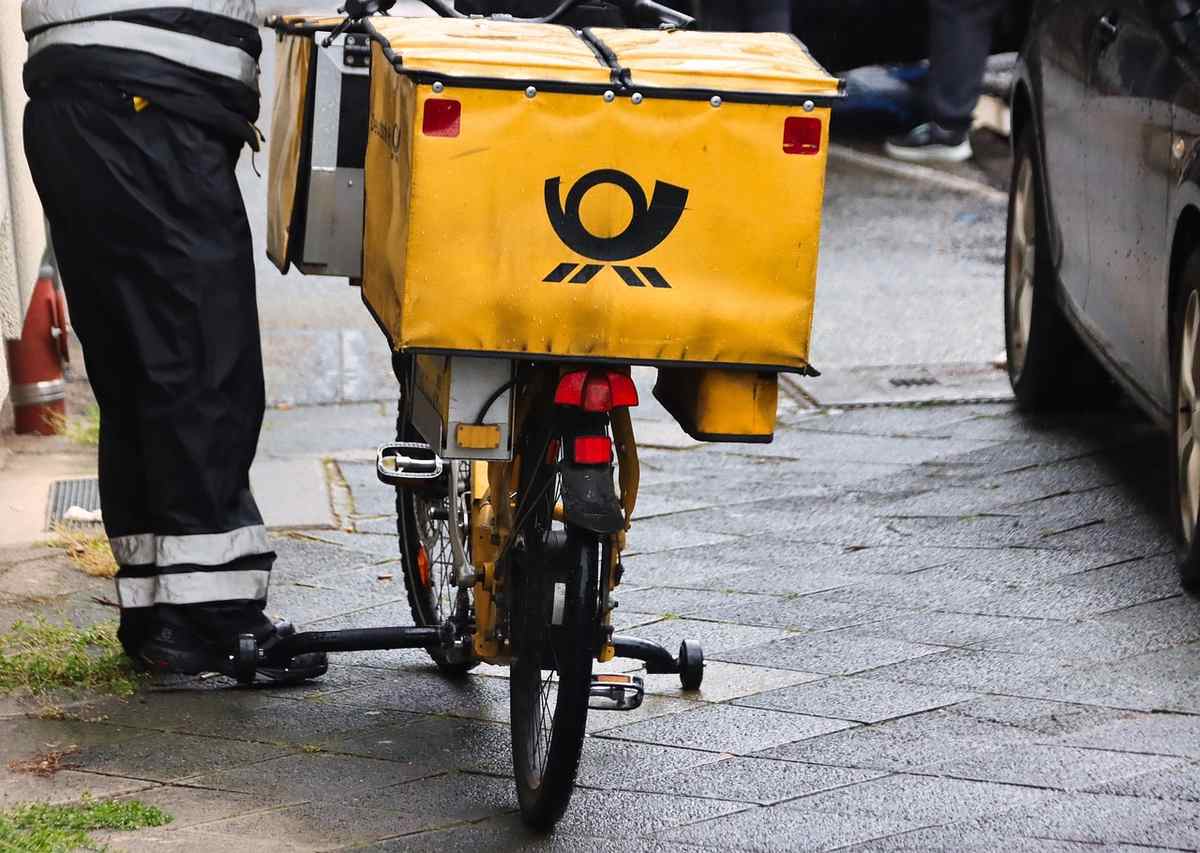 Un livreur en pantalon noir prépare son vélo de livraison