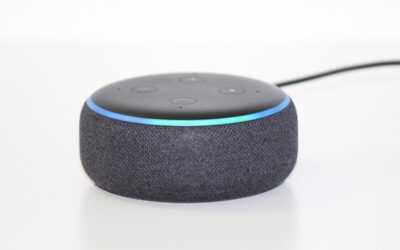Un petit haut-parleur intelligent noir avec anneau lumineux bleu