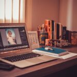 Un ordinateur portable sur un bureau avec livres, calendrier et cahier