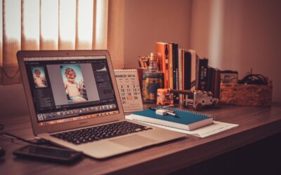 Un ordinateur portable sur un bureau avec livres, calendrier et cahier